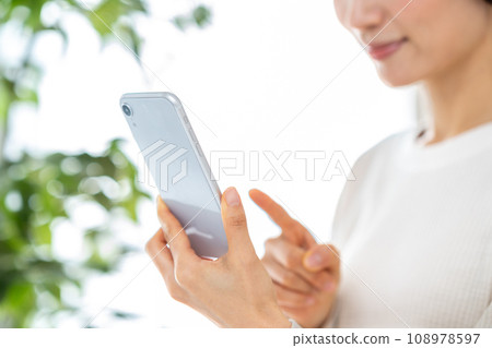 操作智能手機的中年婦女。 108978597