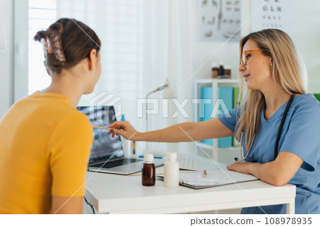 Teenage girl discussing test results with paediatrician. Doctor prescribing medication to ill young girl. Concept of preventive health care for adolescents. 108978935