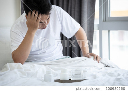Sick middle aged man has severe migraine headache suffer from dizziness,tired asian male holding head,closed eyes,sit on bed,feeling vertigo,dizzy,head pain,illness disease,health problem,health care Sick middle aged man has severe migraine headache suffer from dizziness,tired asian male holding head,closed eyes,sit on bed,feeling vertigo,dizzy,head pain,illness disease,health problem,health care 108980268