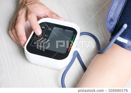 Man check blood pressure monitor and heart rate monitor with digital pressure gauge. Health care and Medical concept Man check blood pressure monitor and heart rate monitor with digital pressure gauge. Health care and Medical concept 108980376