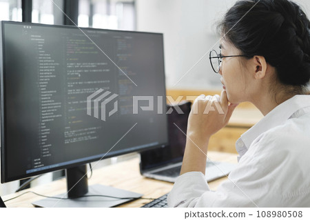 IT Programmer Starts Working on Desktop Computer. IT Programmer Starts Working on Desktop Computer. 108980508