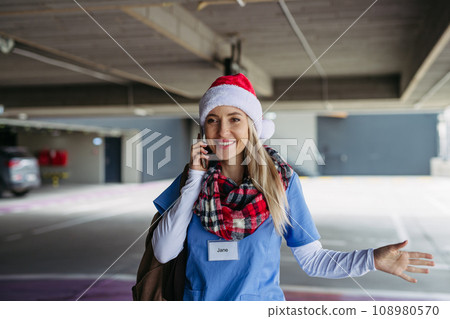 Portrait of beautiful nurse with christmas hat making call. Working in hospital on Christmas day, Christmas Eve. Female doctor working a Christmas shift and can't be with her family. Portrait of beautiful nurse with christmas hat making call. Working in hospital on Christmas day, Christmas Eve. Female doctor working a Christmas shift and can't be with her family. 108980570