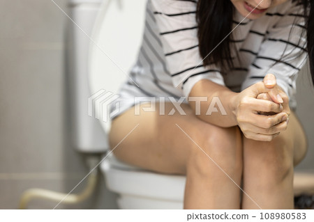 Asian woman suffer from constipation,gut obstruction,disease of intestinal or irritable bowel syndrome,defecation problem,fecal impaction,difficulty in excretion,pain or discomfort from hardened feces 108980583