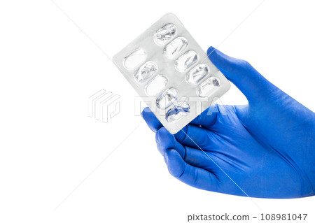 Hand with medical glove holding empty pill blister pack 108981047