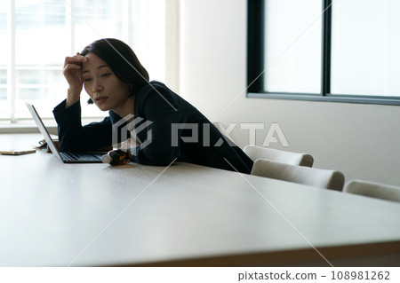 A woman feeling exhausted in the office A woman feeling exhausted in the office 108981262