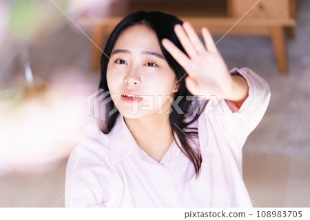 Young woman reaching for cherry blossoms 108983705