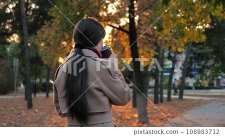 Woman sipping coffee as waiting for business meeting in town park in autumn Woman sipping coffee as waiting for business meeting in town park in autumn 108983712