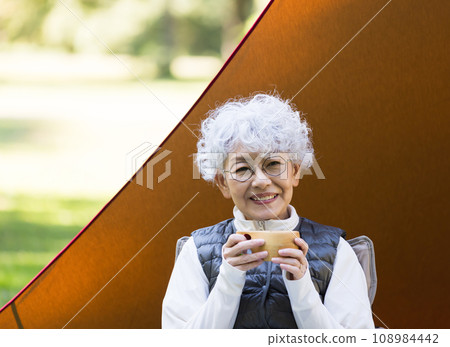 A woman in her 60s enjoying camping A woman in her 60s enjoying camping 108984442