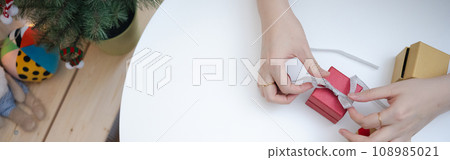 flat lay woman hand decorate christmas tree and new year  gift box and play with her cat 108985021