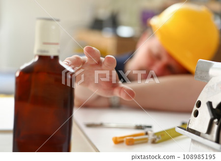 Arm of drunken worker in yellow helmet 108985195
