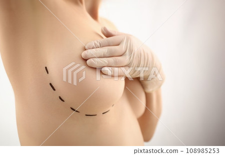 Female hand in gloves holding breast closeup 108985253