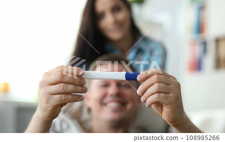 Happy man holding pregnancy test 108985266