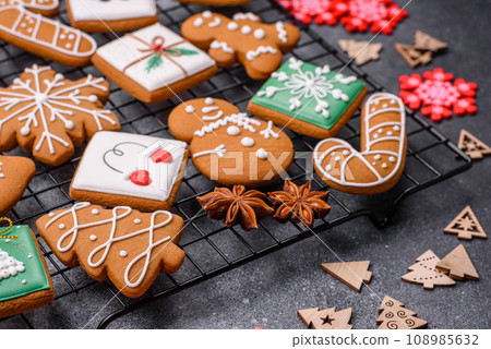 Beautiful delicious sweet winter Christmas gingerbread cookies on a gray textured background Beautiful delicious sweet winter Christmas gingerbread cookies on a gray textured background 108985632