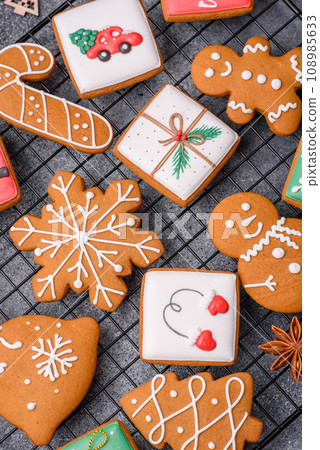 Beautiful delicious sweet winter Christmas gingerbread cookies on a gray textured background Beautiful delicious sweet winter Christmas gingerbread cookies on a gray textured background 108985633