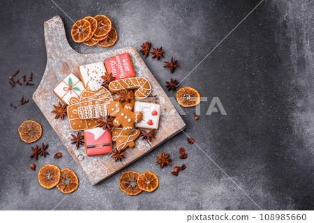 Beautiful delicious sweet winter Christmas gingerbread cookies on a gray textured background 108985660