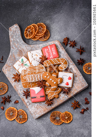 Beautiful delicious sweet winter Christmas gingerbread cookies on a gray textured background Beautiful delicious sweet winter Christmas gingerbread cookies on a gray textured background 108985661