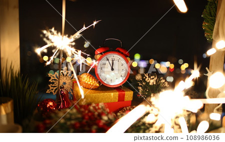 Red alarm clock with christmas gifts against night 108986036