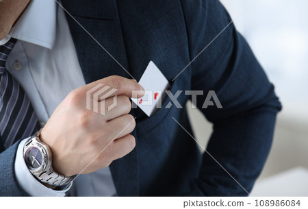 Closeup of mans hand pulling ace card out of suit pocket 108986084
