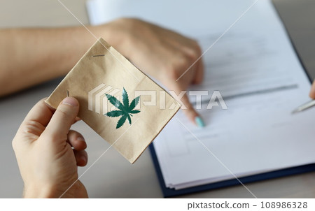 Male arm holding paper packet 108986328