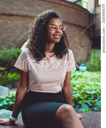 happy cheerful dark skinned woman in stylish sunglasses enjoying leisure outdoors happy cheerful dark skinned woman in stylish sunglasses enjoying leisure outdoors 108986679