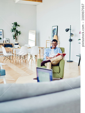 Happy african american hipster guy laughing having fun during free time at home with girlfriend Happy african american hipster guy laughing having fun during free time at home with girlfriend 108987087