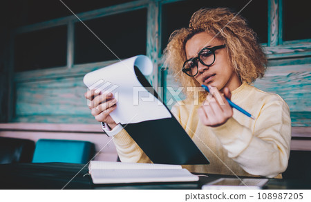 intelligent hipster girl in stylish eyeglasses working during organisation 108987205