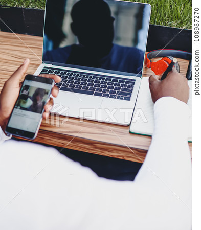 Cropped image of dark skinned male journalist working remotely on idea 108987270