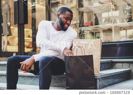 positive african american male happy about buying clothing in wear store with good discount positive african american male happy about buying clothing in wear store with good discount 108987329