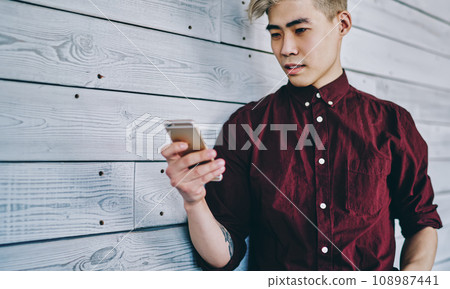 Chinese young man blogging on mobile phone using 4G internet Chinese young man blogging on mobile phone using 4G internet 108987441