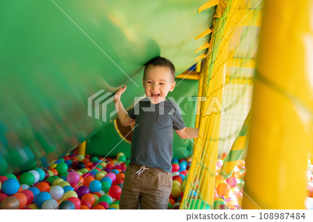 Happy smiling toddler boy playing in children's playroom. Active lifestyle, childhood. Selective focus 108987484