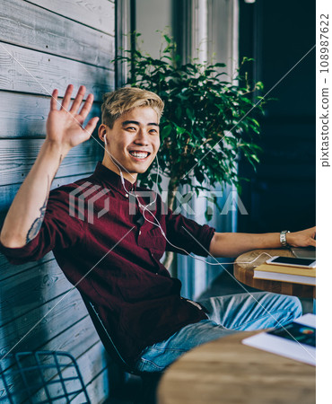 Positive japanese young man updating software on netbook 108987622