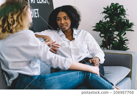 Multicultural friends communicating with each other at home interior 108987708
