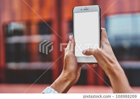 Cropped image of woman's hands holding modern smartphone with mock up screen, Cropped image of woman's hands holding modern smartphone with mock up screen, 108988209