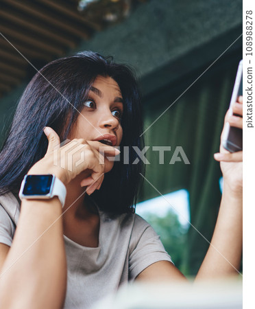 amazed young woman surprised with sales in web store getting mail on cellular 108988278