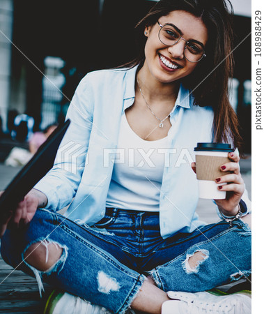 Positive hipster girl resting with caffeine beverage 108988429