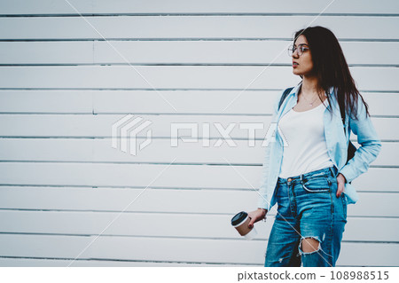Attractive hipster girl holding tasty coffee to go in hand Attractive hipster girl holding tasty coffee to go in hand 108988515