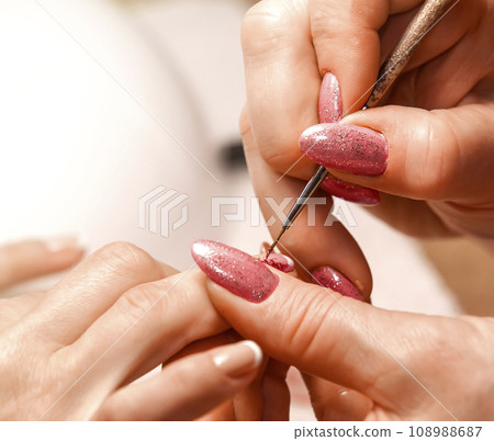 Master of manicure paints nails. Selective focus 108988687