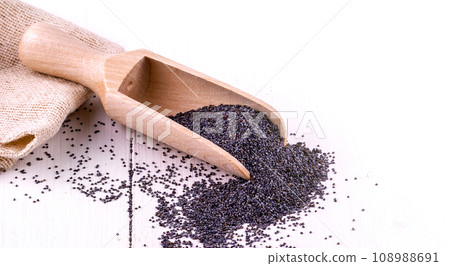 Poppy seeds in a wooden spoon on a white table and burlap Poppy seeds in a wooden spoon on a white table and burlap 108988691