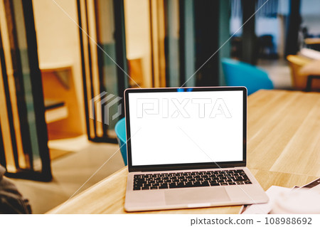 Laptop computer with mock up screen standing on working place near stuff and coffee cup Laptop computer with mock up screen standing on working place near stuff and coffee cup 108988692