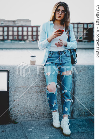 Charming hipster girl tourist standing in urban setting Charming hipster girl tourist standing in urban setting 108988715