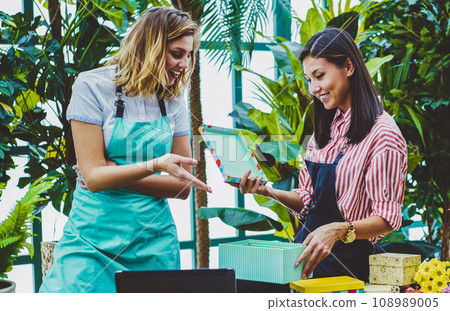 young successful female partners collaborating together in botanic warmhouse young successful female partners collaborating together in botanic warmhouse 108989005