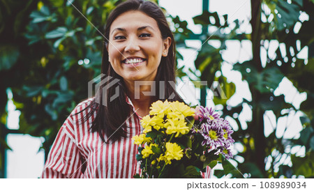 happy asian florist enjoying time in flowers orangery happy asian florist enjoying time in flowers orangery 108989034