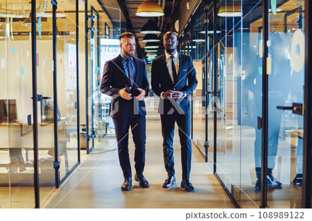 .Two multicultural entrepreneurs going on corridor 108989122