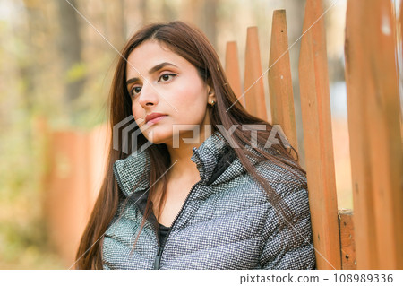 Close-up portrait of diversity young beautiful confident Indian Asian woman in fall outdoor. Happy and natural smiling female. Generation z and gen z youth concept 108989336