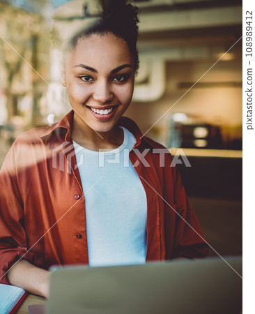 Portrait of happy female student spending time in coworking space Portrait of happy female student spending time in coworking space 108989412