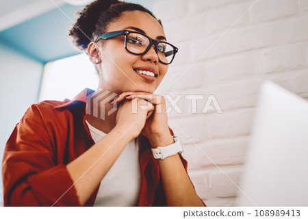 skilled student sitting at table with modern laptop device 108989413