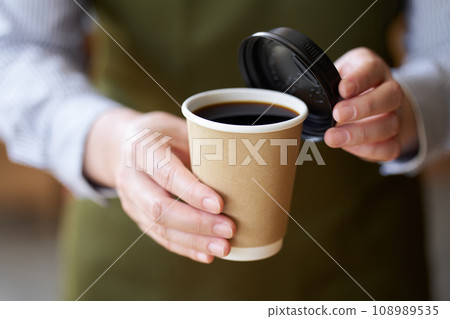 Hand of a cafe clerk offering coffee 108989535