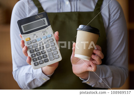 Cafe clerk with coffee and calculator Cafe clerk with coffee and calculator 108989537