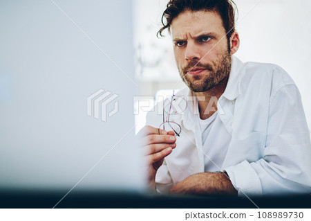 Serious concentrated businessman read news from exchange online via laptop computer 108989730