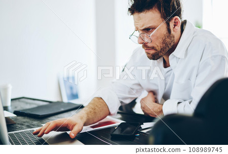 man freelancer read publication in blog via netbook work from home at desktop 108989745